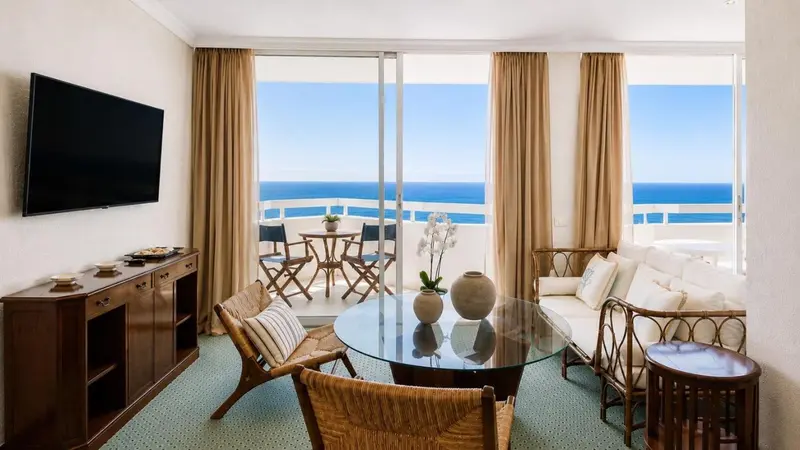 Un salon lumineux s'ouvre sur une terrasse avec vue sur la mer.