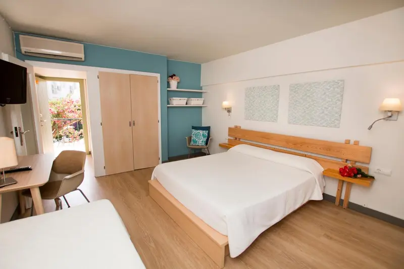 Une chambre lumineuse avec un lit double et un bureau.