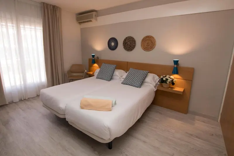 Une chambre lumineuse avec un grand lit et des décorations murales.