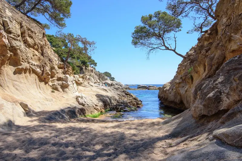Une petite crique rocheuse s'ouvre sur la mer turquoise.