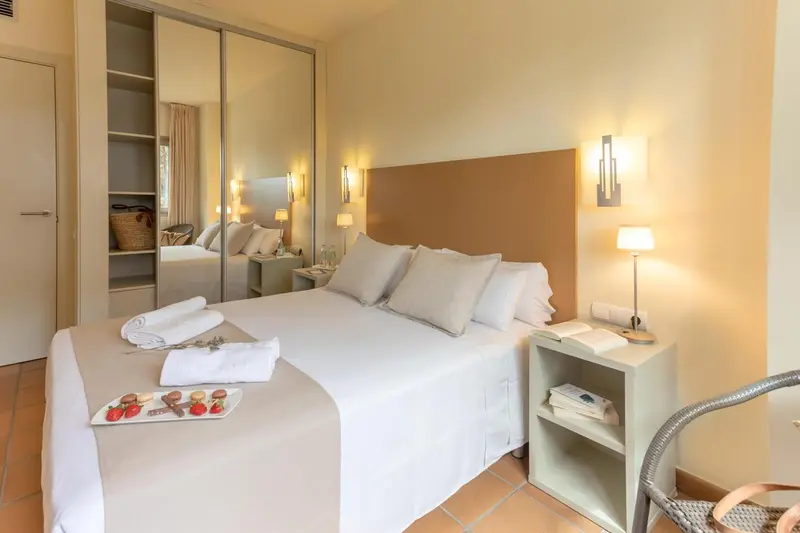 Une chambre lumineuse avec un grand lit et des rangements intégrés.