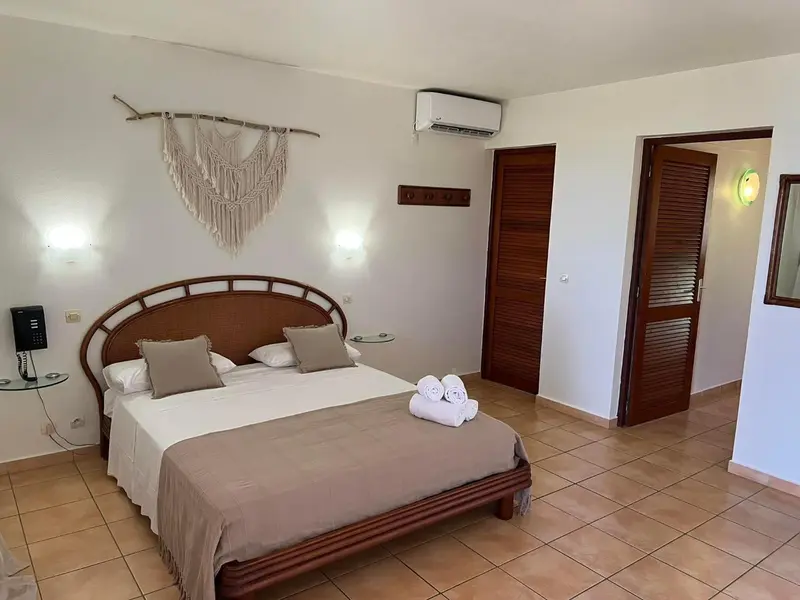 Une chambre lumineuse avec un grand lit et une décoration murale.