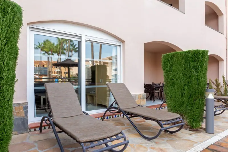 Deux transats invitent à la détente sur une terrasse ensoleillée.