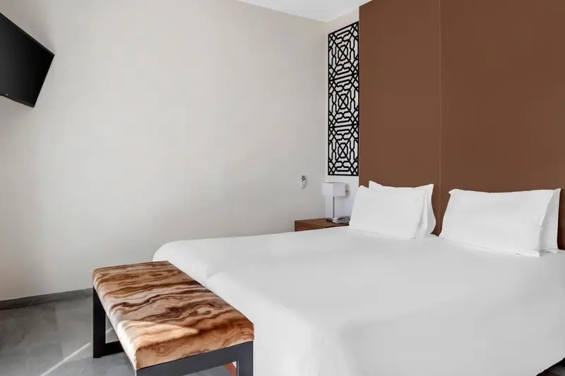 Une chambre lumineuse avec un grand lit et une décoration sobre.