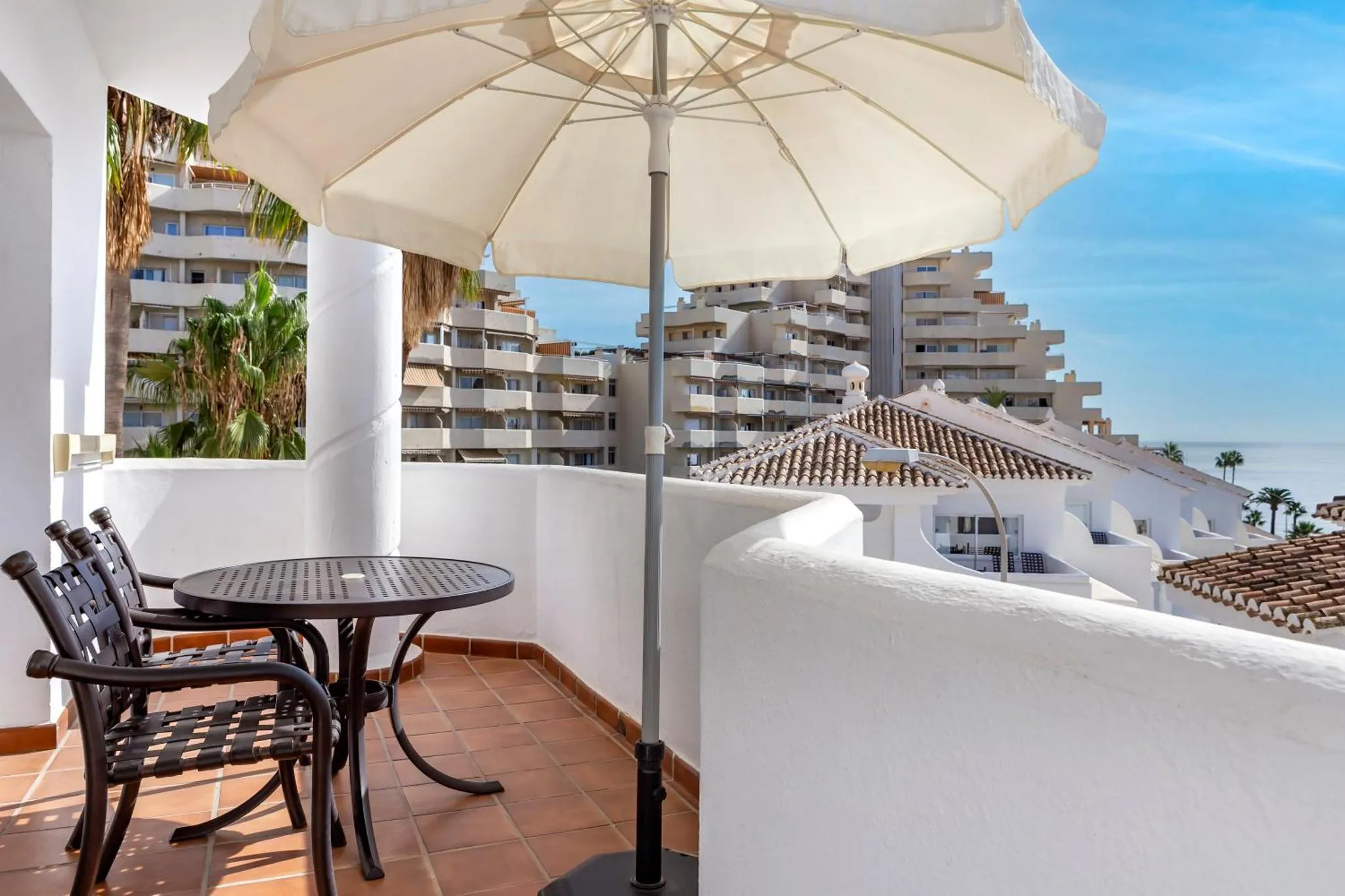 Terrasse avec mobilier de jardin et vue sur la mer.