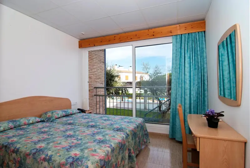 Une chambre lumineuse avec un lit et un accès à une terrasse.