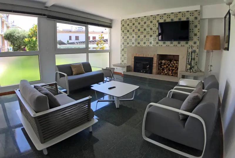 Espace de détente intérieur avec canapés, table basse et télévision.