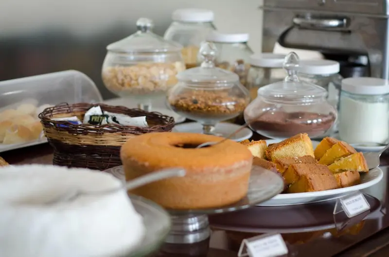 Une table basse présente une variété de pâtisseries et de céréales dans des récipients en verre.