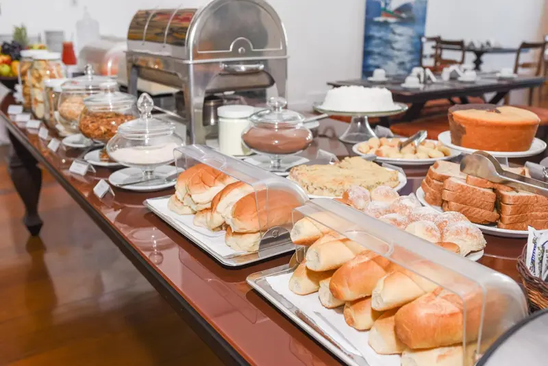 Un buffet propose une variété de pâtisseries, de pains et de céréales.