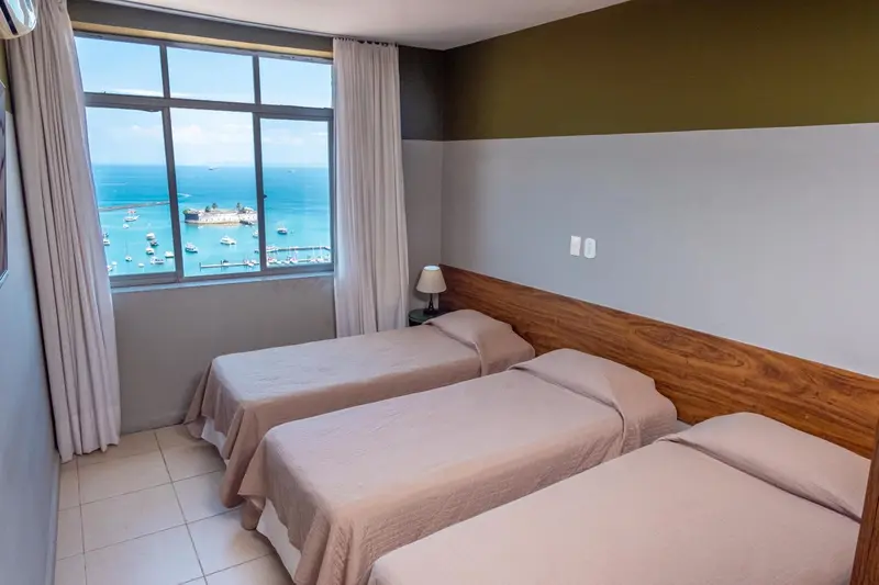 Chambre avec deux lits simples et vue sur la mer.