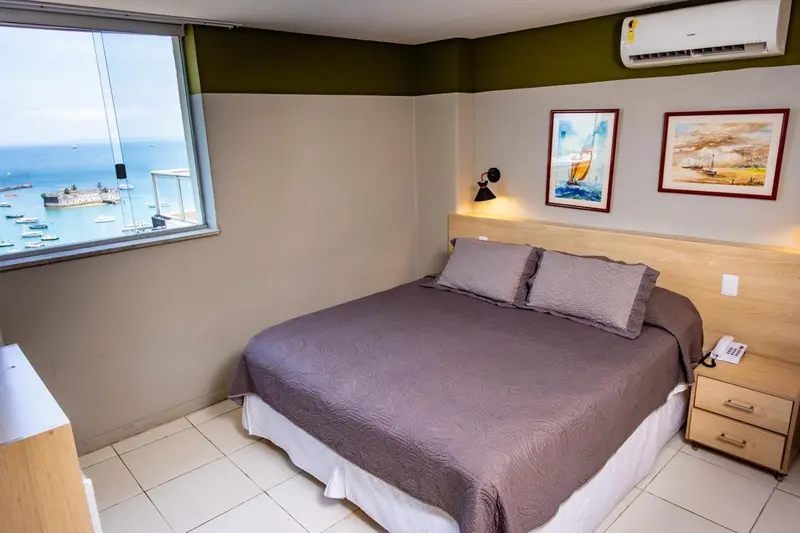 Chambre avec un grand lit et une vue sur le port.
