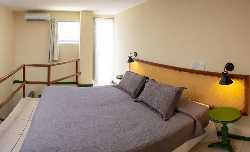 Une chambre lumineuse avec un grand lit et une décoration sobre.