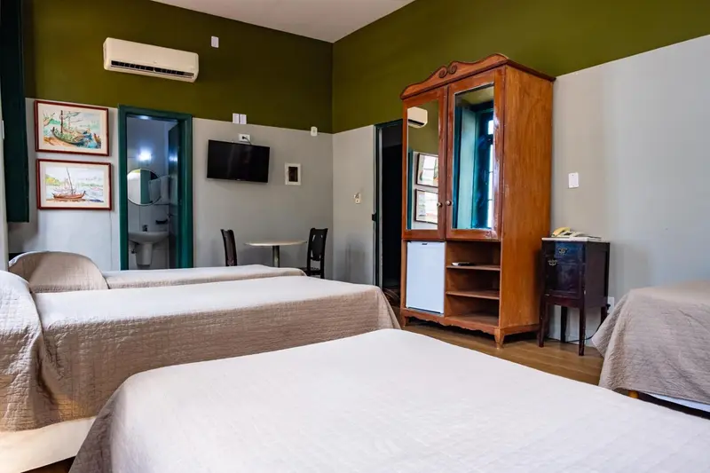 Une chambre lumineuse avec deux lits simples et un meuble en bois.