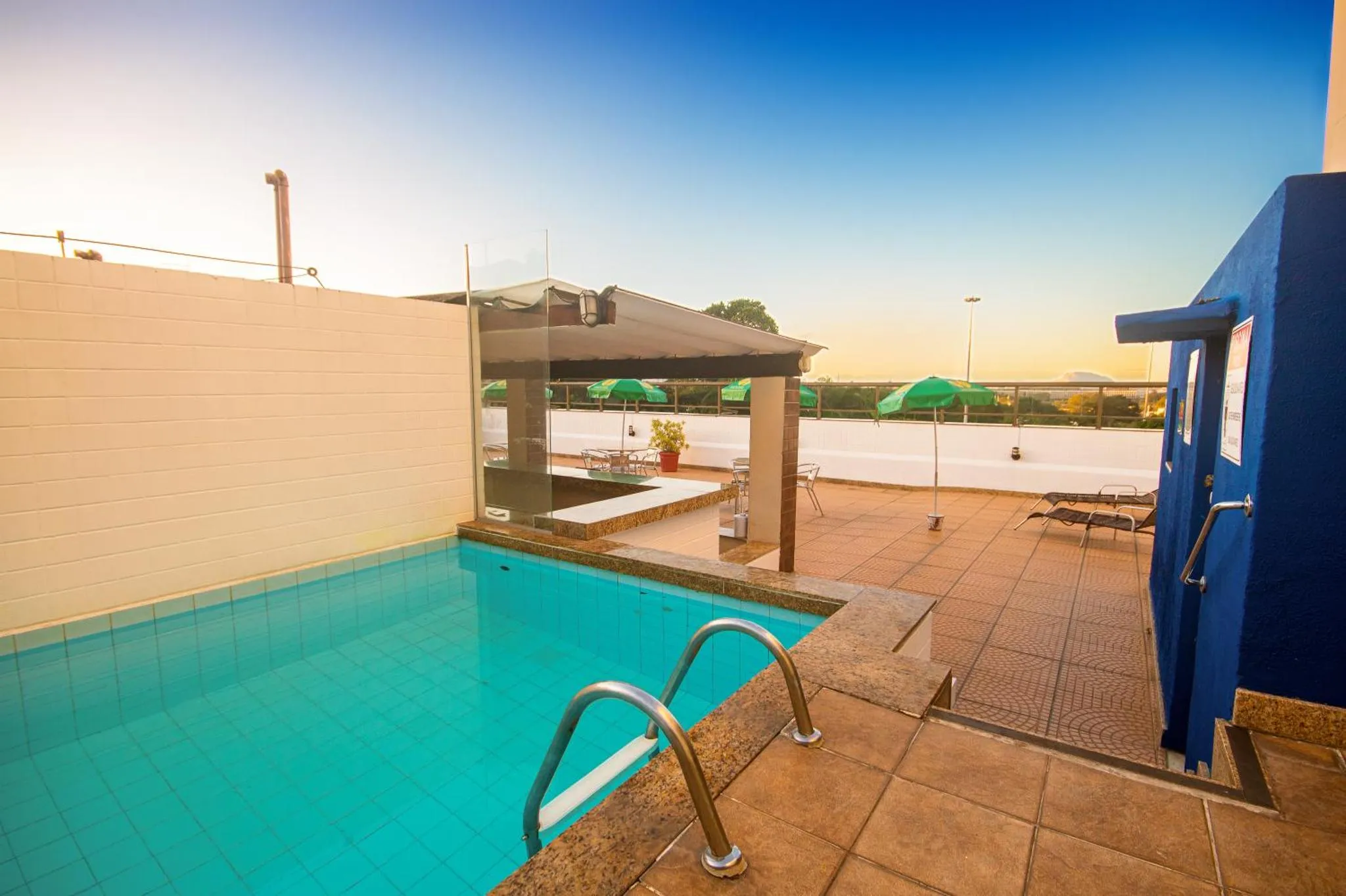 Une piscine rectangulaire avec des transats et des parasols sur un toit-terrasse.
