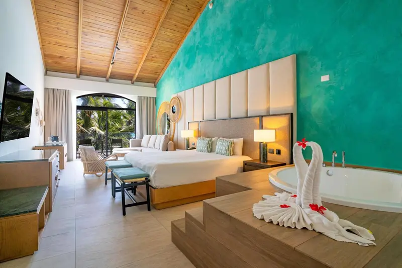 Une chambre spacieuse avec un grand lit et une baignoire à remous.