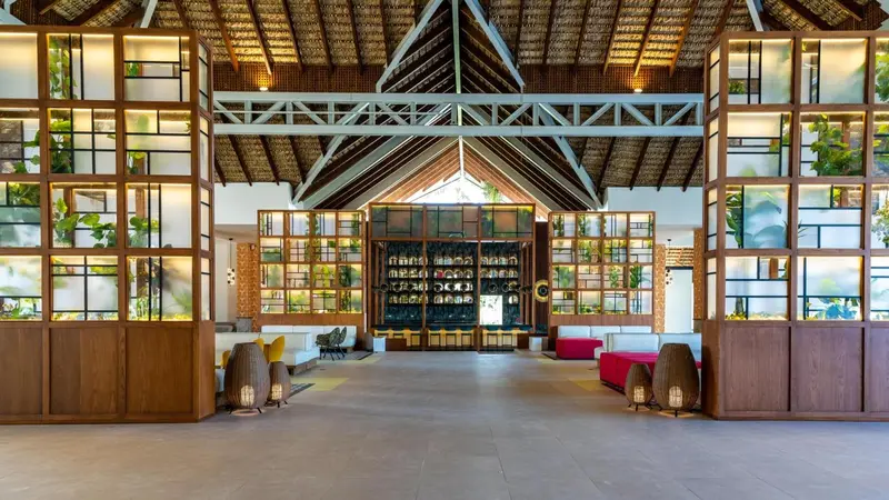 Vaste hall d'accueil lumineux avec mobilier contemporain et décorations végétales.