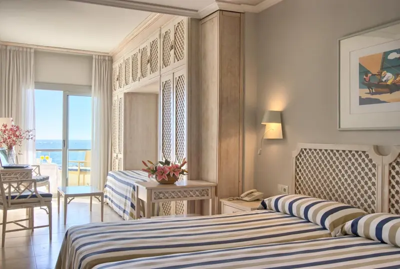 Chambre lumineuse avec vue sur la mer et balcon.