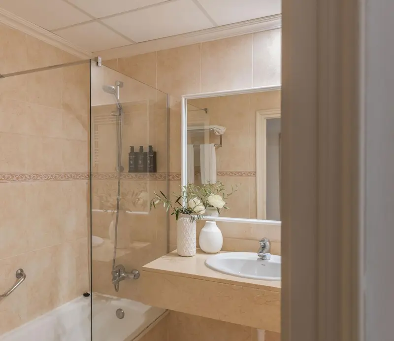 Une salle de bain claire avec une douche et un lavabo.