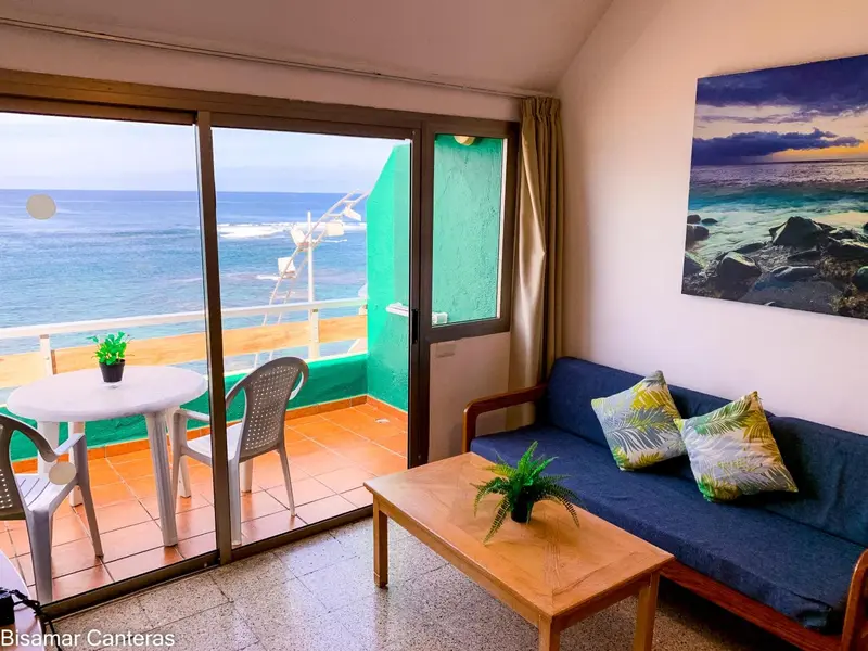Un salon lumineux s'ouvre sur une terrasse avec vue sur la mer.