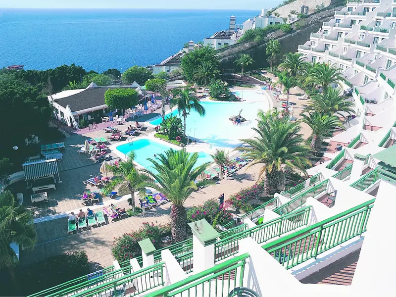 Vue aérienne d'un complexe hôtelier avec piscine et végétation luxuriante.