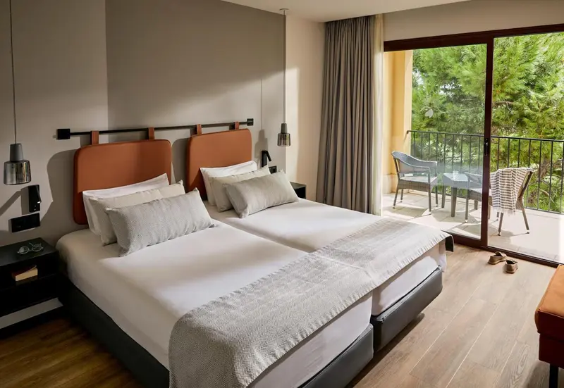 Une chambre lumineuse avec un grand lit et un accès à une terrasse.