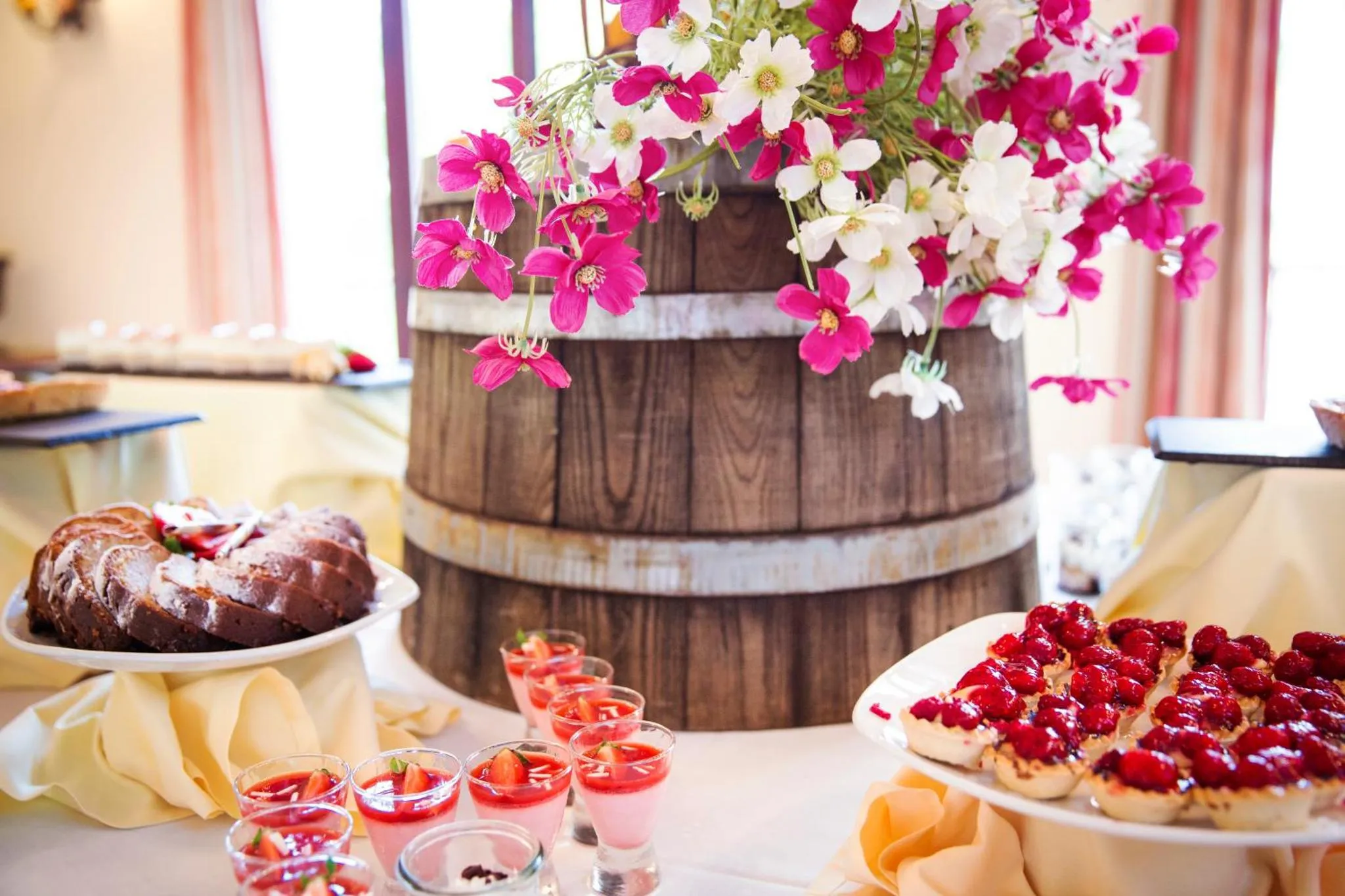 Une table garnie de desserts variés et de fleurs colorées.