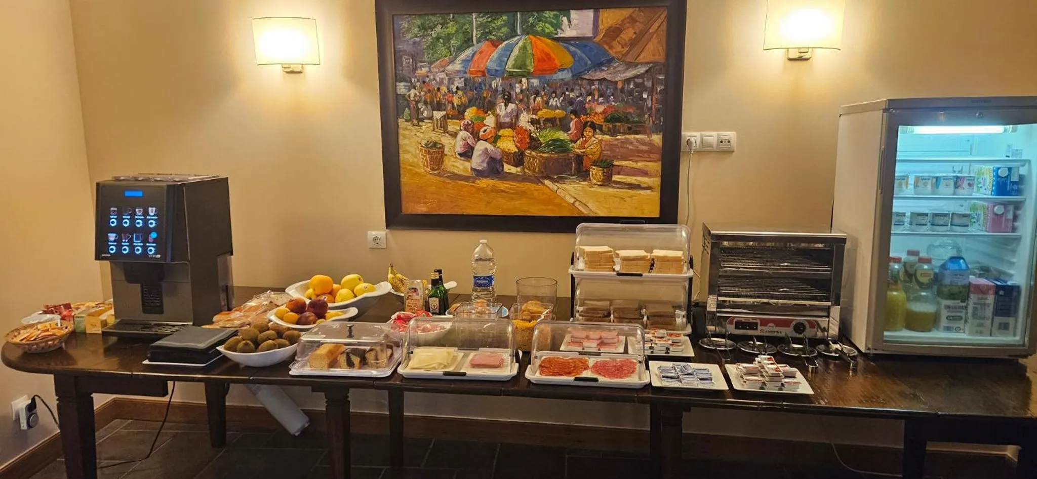 Un comptoir de buffet propose des viennoiseries, des fruits et des boissons.