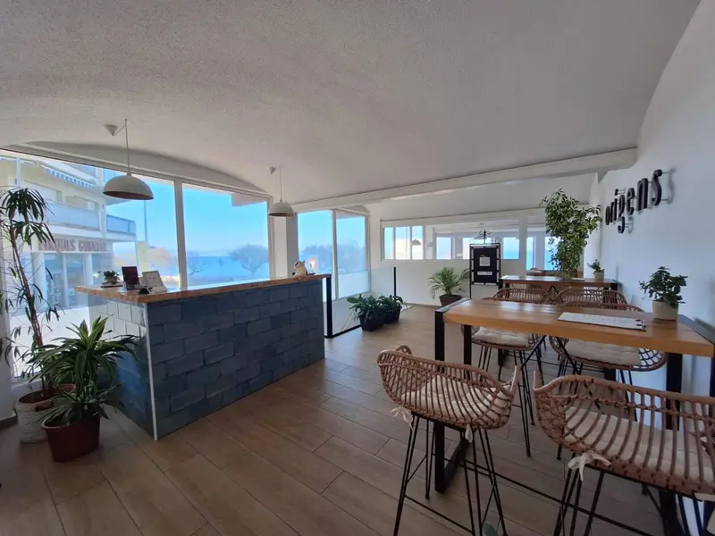 Espace lumineux avec un comptoir d'accueil et des tables.