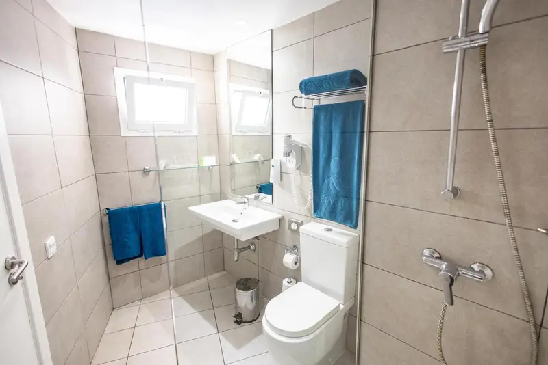Une salle de bain claire avec douche et lavabo.