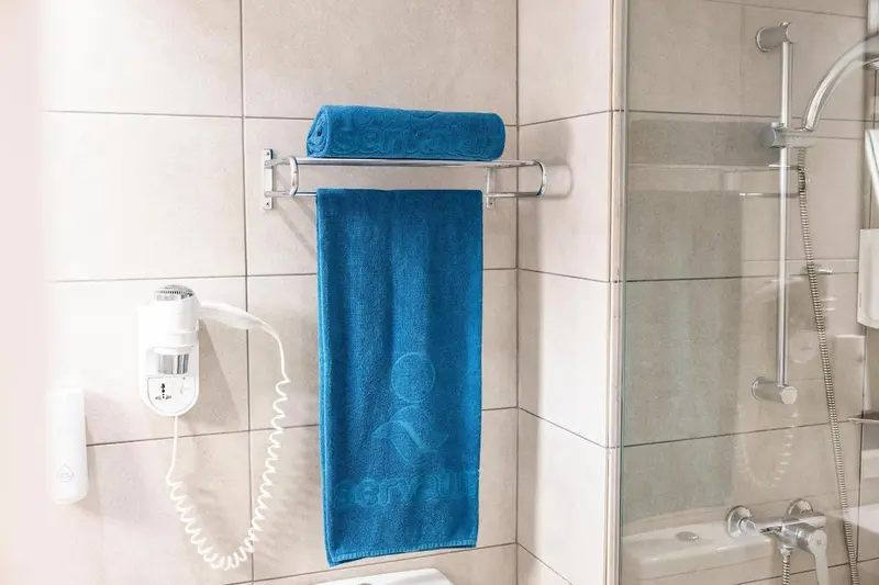 Serviettes bleues suspendues dans une salle de bain carrelée.
