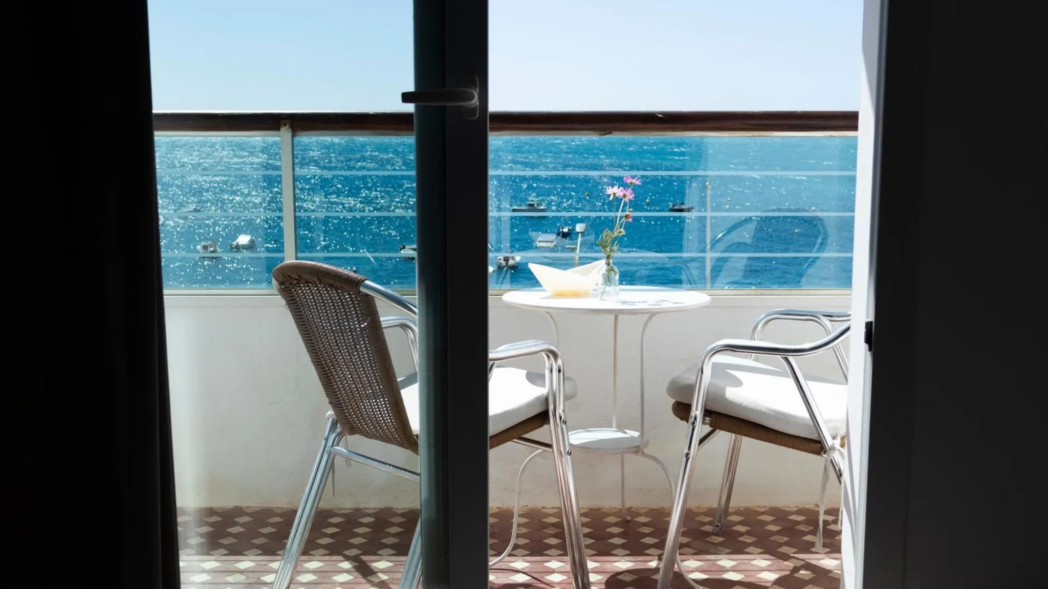 Une terrasse avec une table et des chaises offre une vue sur la mer.