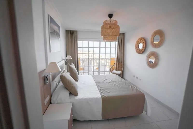 Une chambre lumineuse avec un grand lit et des décorations murales.
