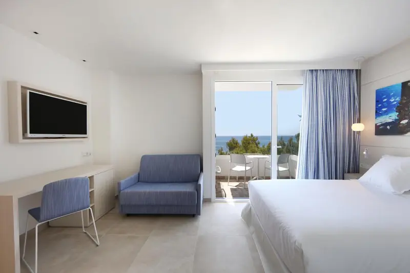 Une chambre lumineuse avec un canapé et un accès à un balcon.