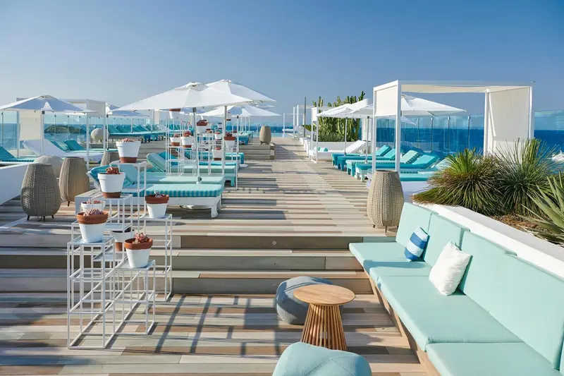 Terrasse aménagée avec des transats et des canapés turquoise.