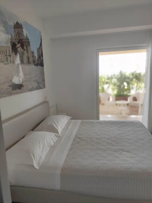 Une chambre lumineuse avec un grand lit et une vue sur la végétation.