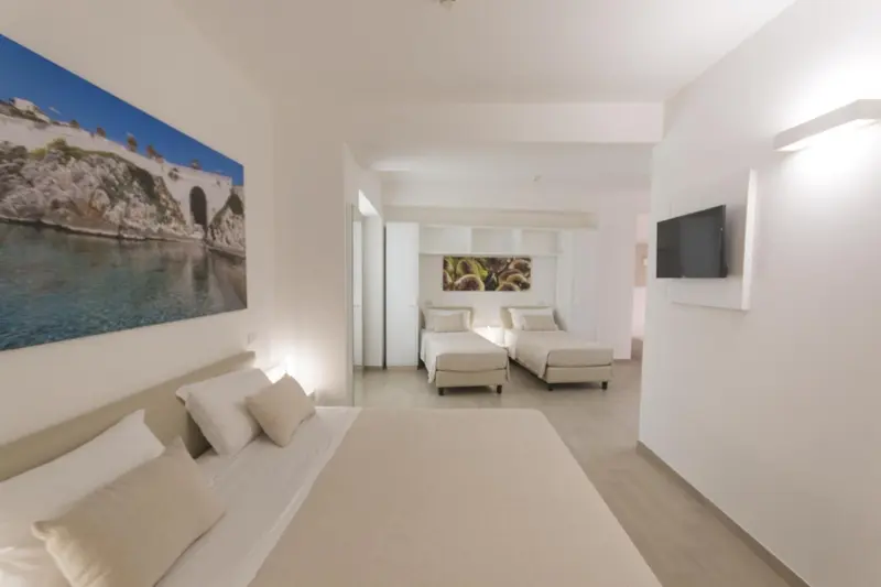 Chambre lumineuse avec lits simples et décoration murale.