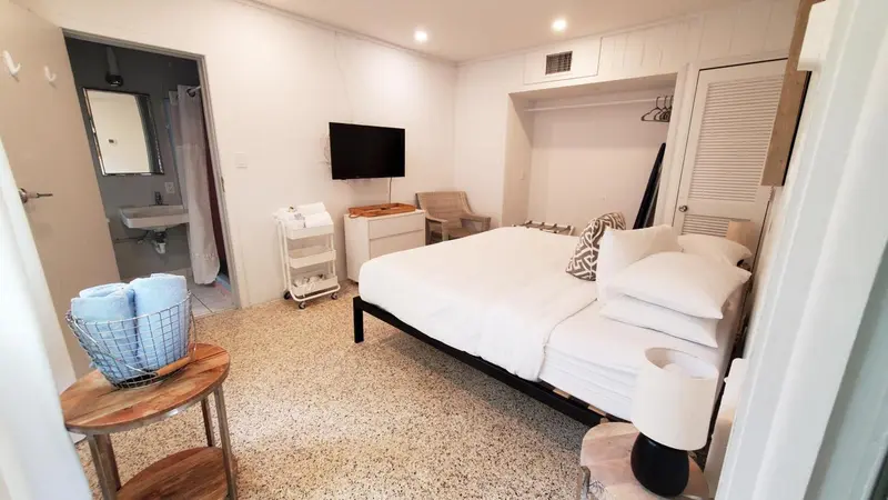 Une chambre lumineuse avec un lit et un accès à une salle de bain.