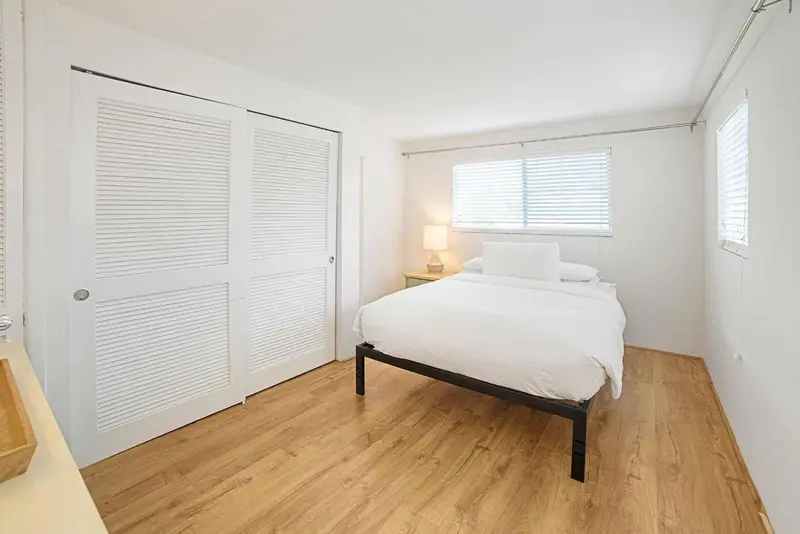 Une chambre lumineuse avec un lit et un placard.