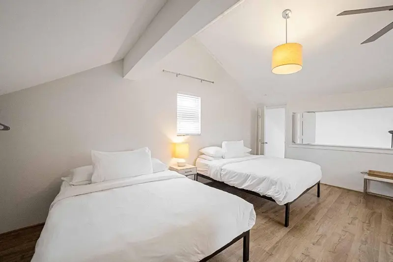 Une chambre lumineuse avec deux lits simples et une décoration minimaliste.