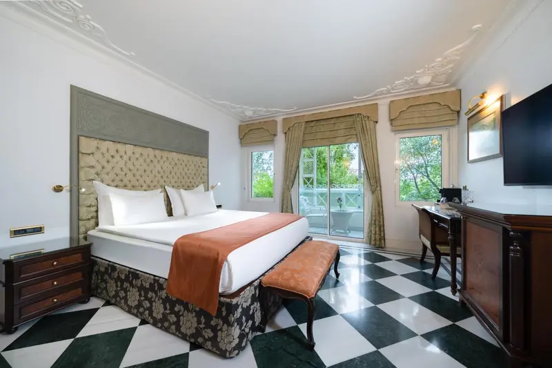Une chambre lumineuse avec un grand lit et un accès à une terrasse.