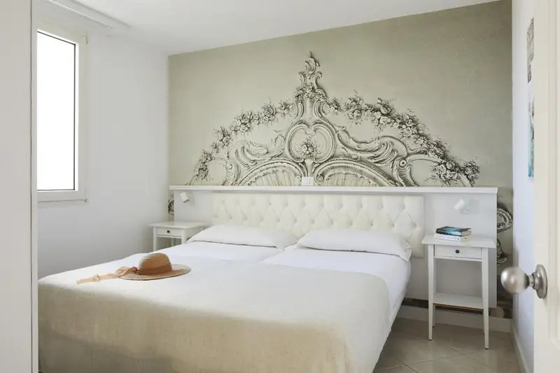 Une chambre lumineuse avec un grand lit et une décoration murale ornée.