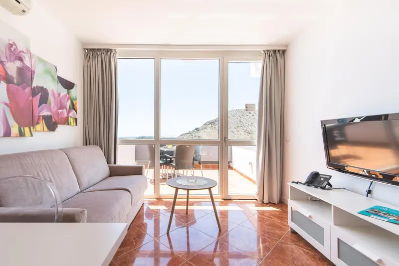Un salon lumineux s'ouvre sur une terrasse avec vue sur le paysage.