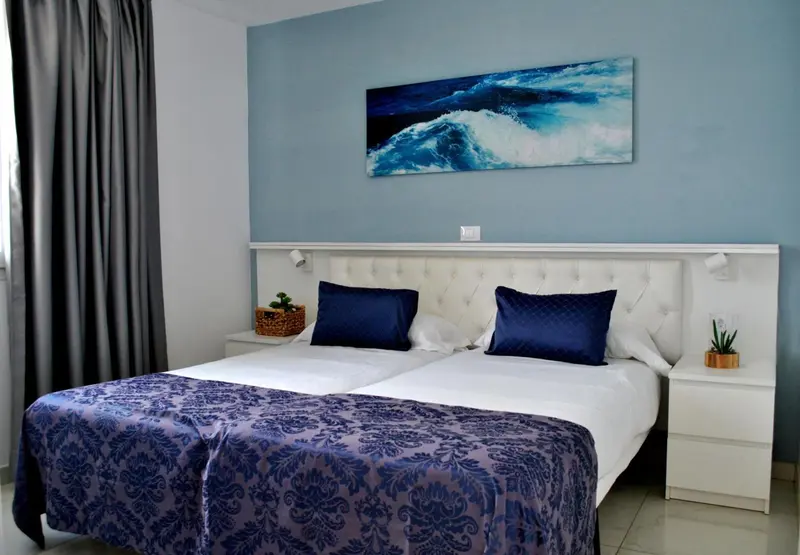 Une chambre avec un grand lit et une décoration sobre.