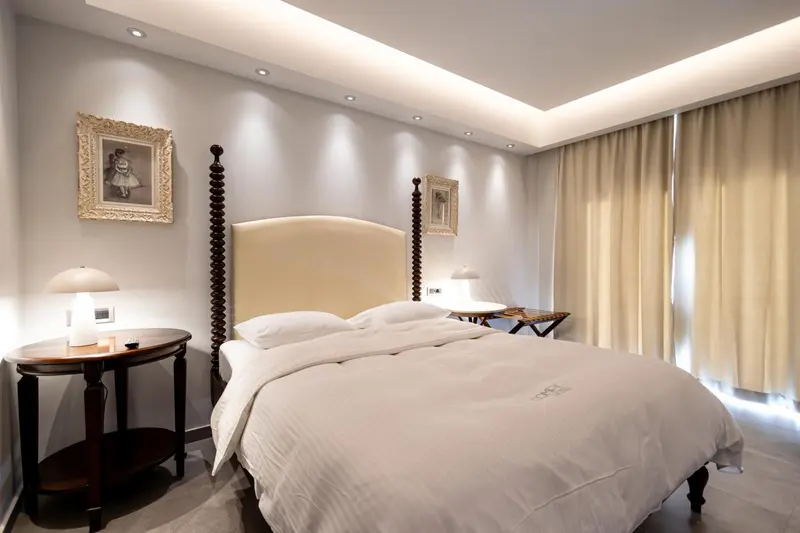 Une chambre lumineuse avec un grand lit à baldaquin et des tables de chevet.