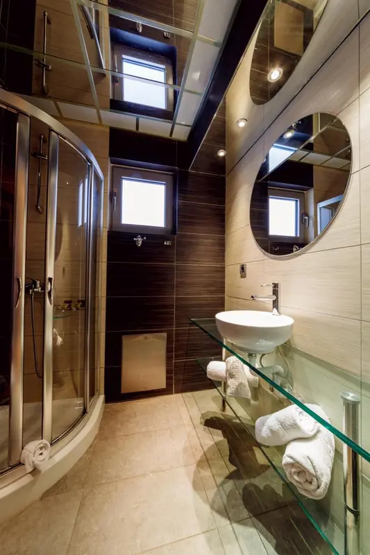 Une salle de bain moderne avec douche à l'italienne et vasque sur meuble vitré.