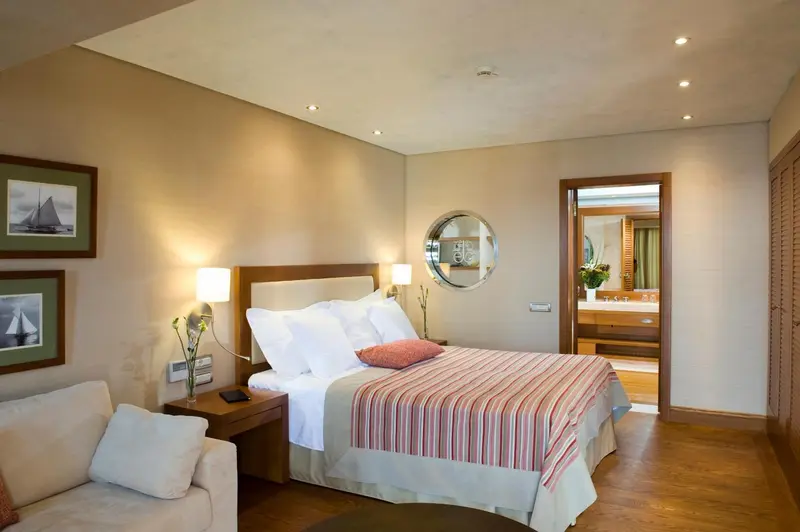 Une chambre lumineuse avec un grand lit et un coin salon.