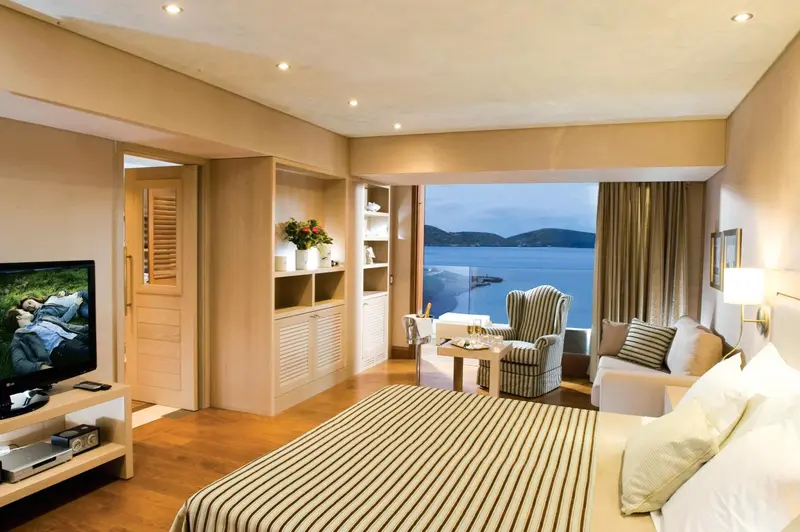 Espace de vie lumineux avec canapé, télévision et vue sur la mer.