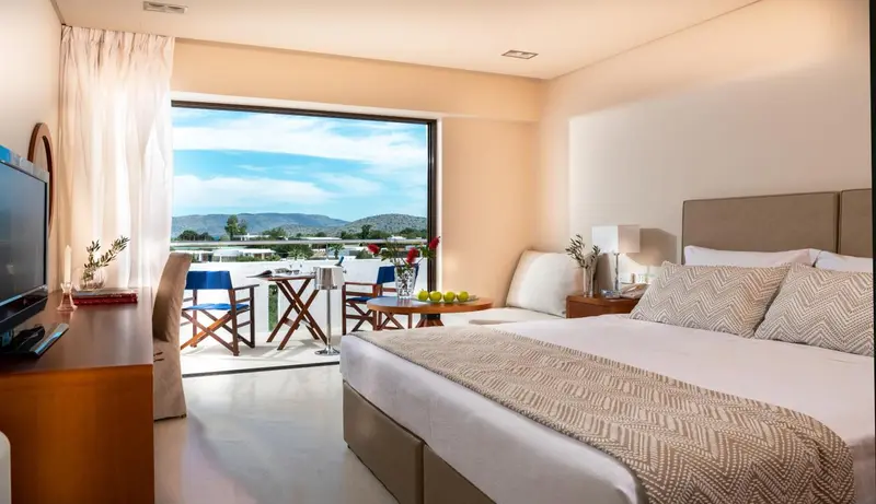 Une chambre lumineuse s'ouvre sur une terrasse avec vue sur la mer.