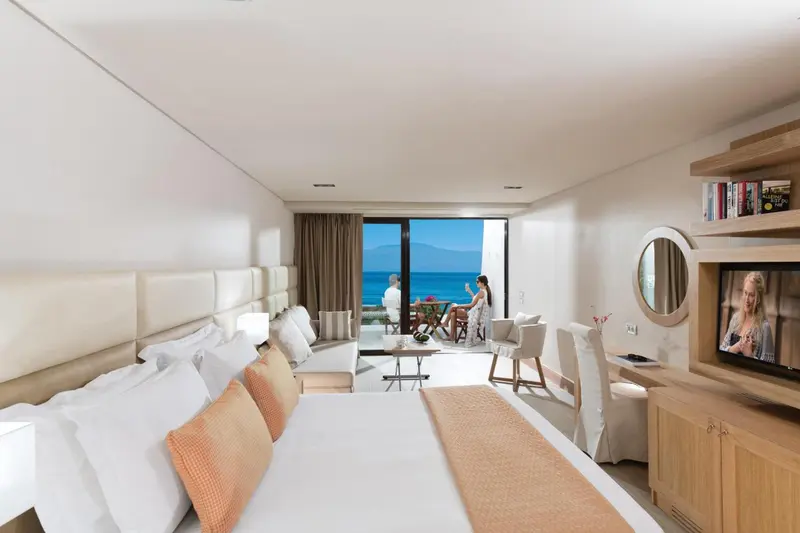 Une chambre lumineuse avec un grand lit et une vue sur la mer.