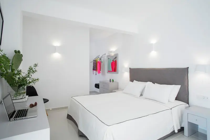 Une chambre lumineuse avec un grand lit et un bureau.